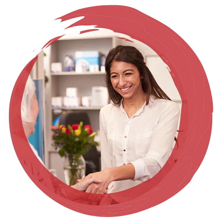 Person shaking hands with another person inside a clinic setting, framed by a red circular graphic.