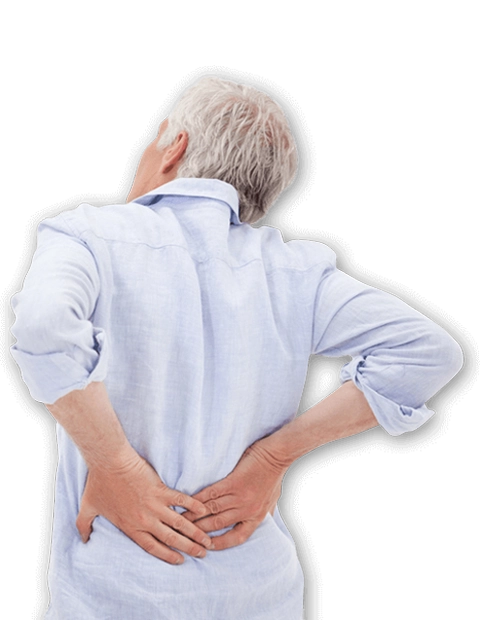 Rear view of a person standing against a black background with both hands placed on the lower back.